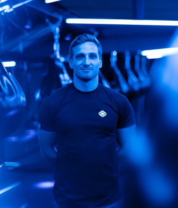 Man performing a controlled strength exercise in a modern gym setting.