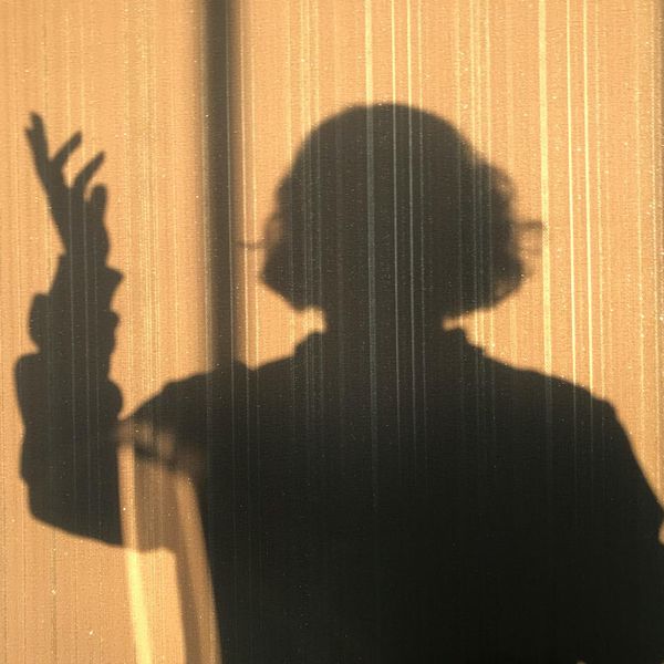Silhouette of a person in a thoughtful pose against a minimalist background.